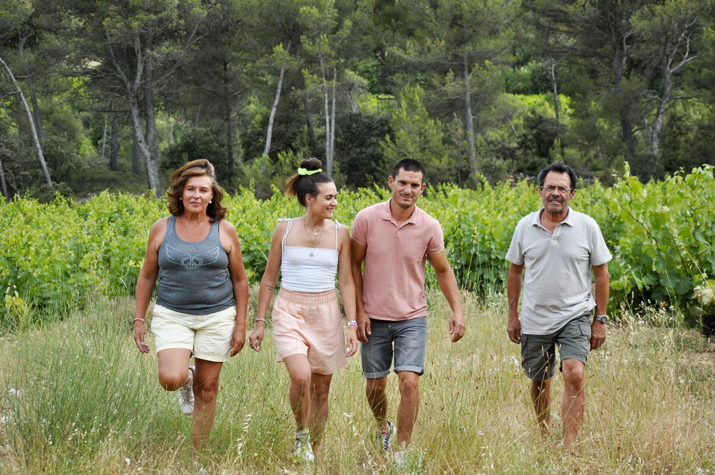 Quatre membres de Villa Minna Vineyard marchent dans les vignes.